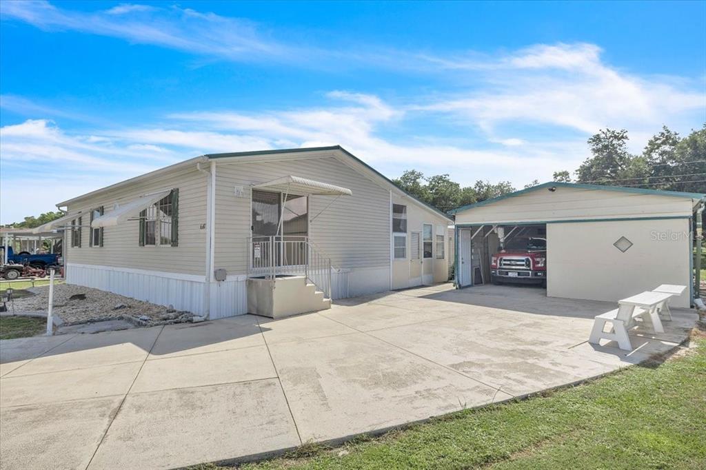 A light-colored manufactured home with an attached carport and a concrete driveway — 6801 BERNADEAN BOULEVARD, PUNTA GORDA, FL