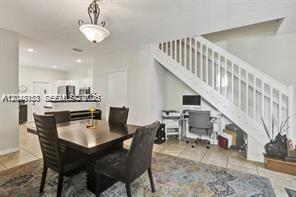 A dining area with a wooden table and chairs sits beside a staircase and desk — 3901 San Simeon Ln, Weston FL 33331, WESTON, FL