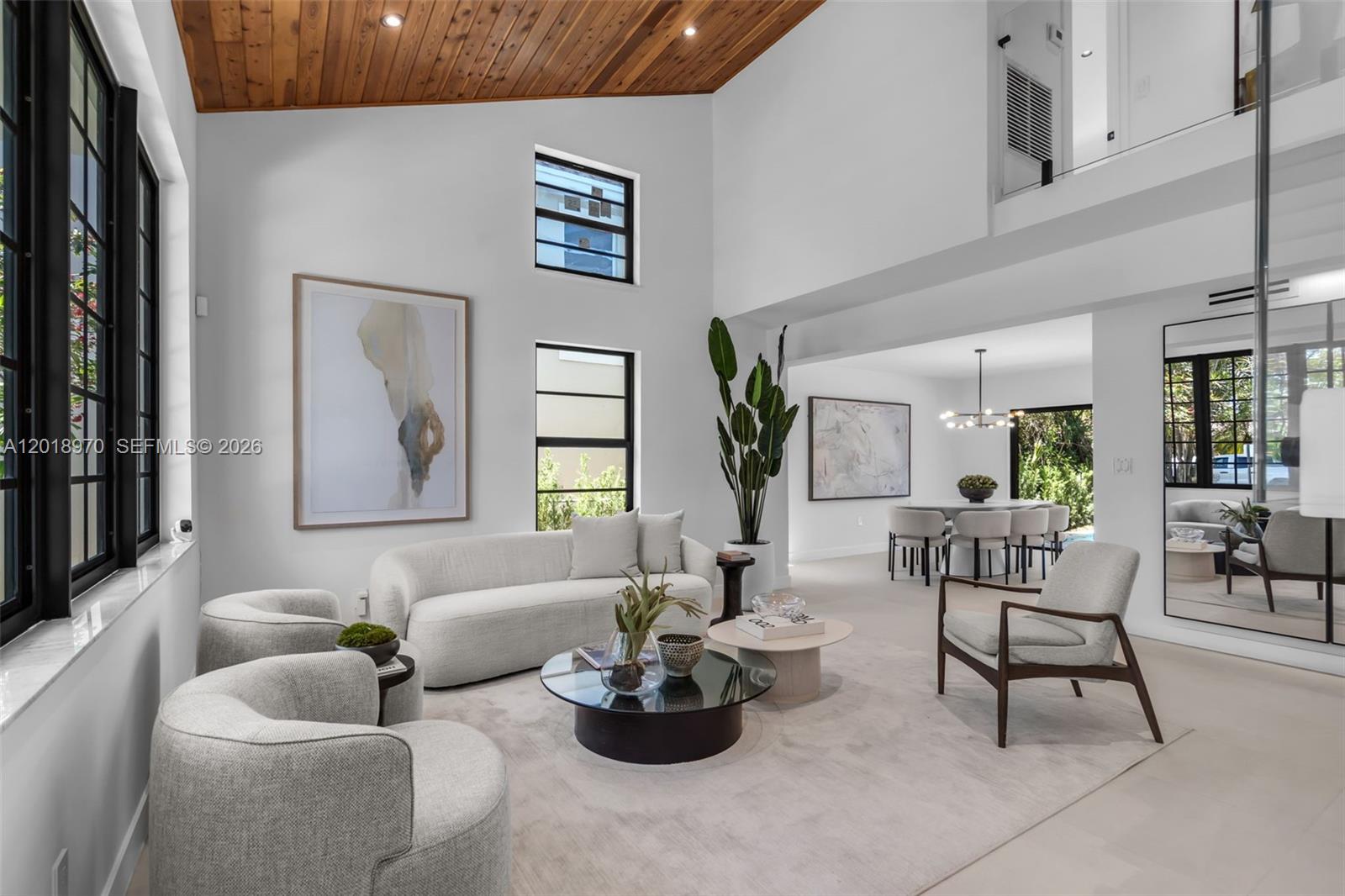 A modern living room with high ceilings, wood paneling, and neutral furniture — 1415 Trillo Ave, Coral Gables FL 33146, CORAL GABLES, FL