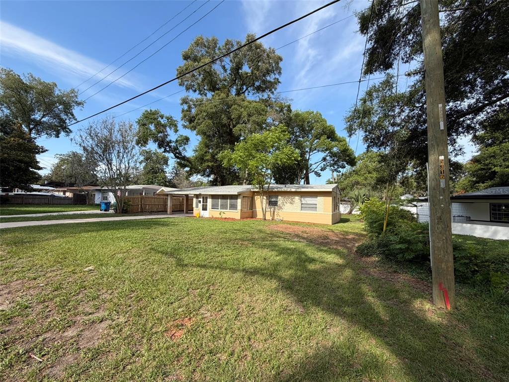 A single-story house with a tan exterior and a carport sits on a grassy lot — 5318 S RIVER ROAD, JACKSONVILLE, FL