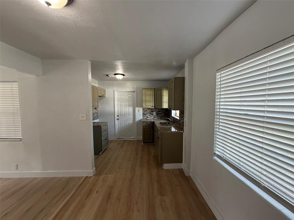 A kitchen features wood-look flooring, granite countertops, and light-colored cabinetry — 5318 S RIVER ROAD, JACKSONVILLE, FL