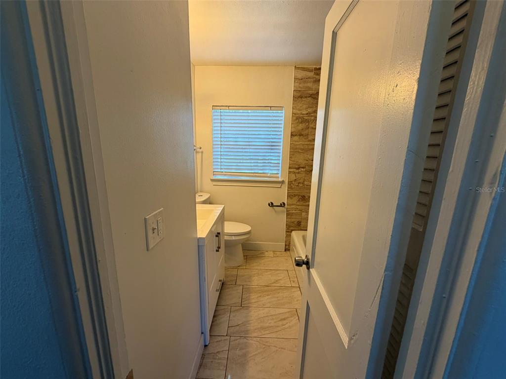 A bathroom with a white vanity, a toilet, and a tiled shower area — 5318 S RIVER ROAD, JACKSONVILLE, FL