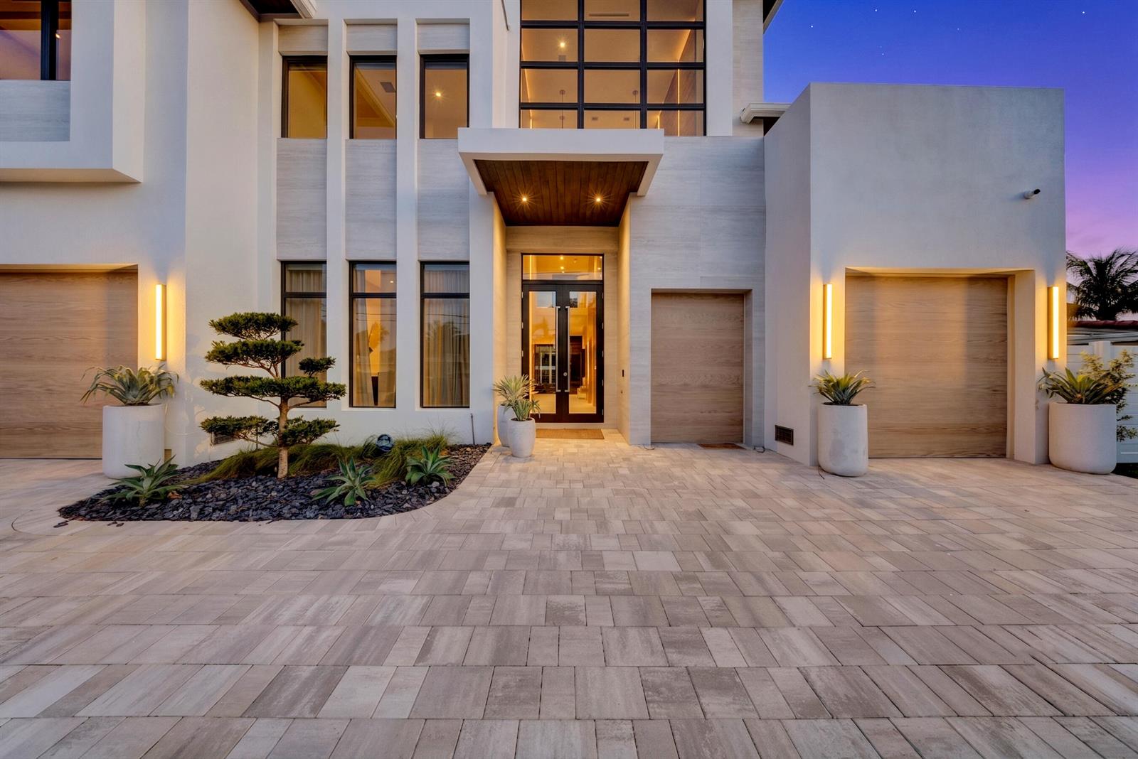 A modern two-story house exterior features a paved driveway, wood-paneled garage doors, and landscaping — 748 NE 72nd Street, Boca Raton FL 33487, BOCA RATON, FL