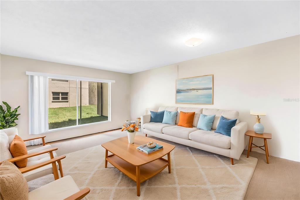 A living room features a beige sofa, wooden coffee table, two armchairs, and a large window — 7701 STARKEY ROAD UNIT 521, SEMINOLE, FL