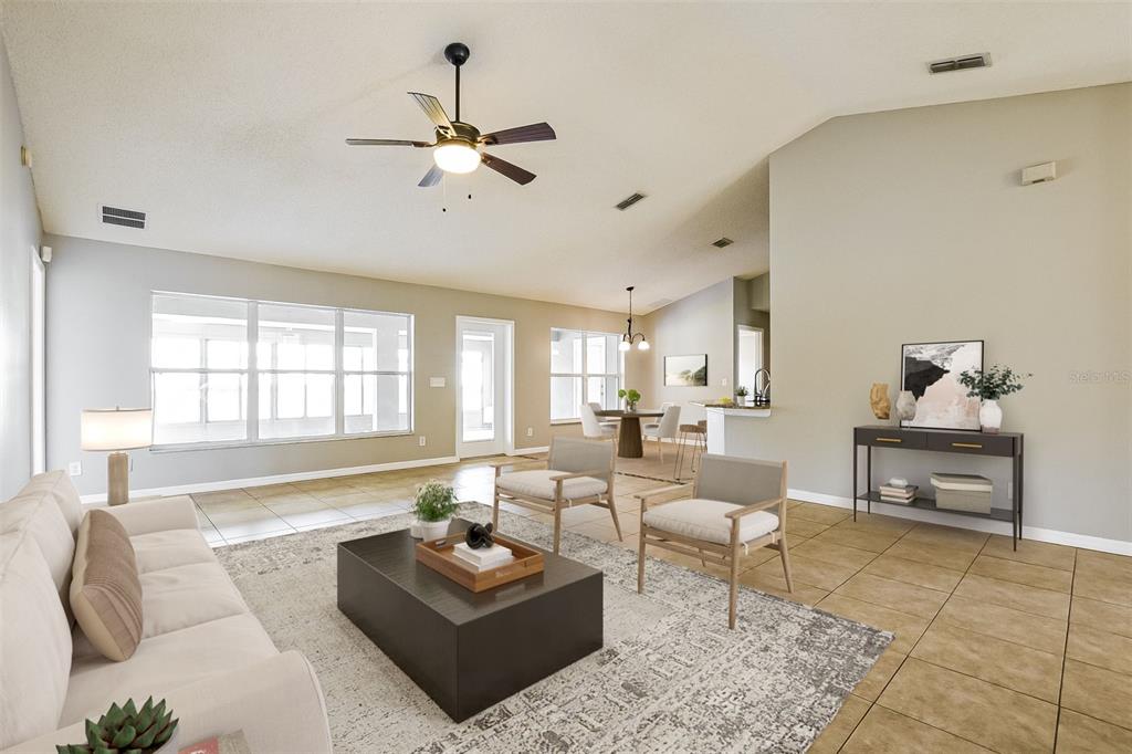 A living room with tile floors, a ceiling fan, and a neutral-toned sofa and chairs — 2091 FAWN MEADOW CIRCLE, ST CLOUD, FL