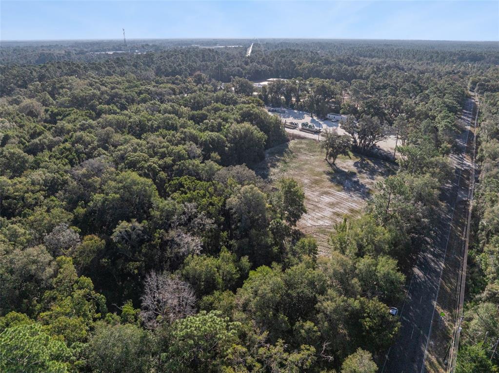 An aerial view shows a wooded lot adjacent to a road and a cleared area — 589 S VOLUSIA AVENUE, PIERSON, FL