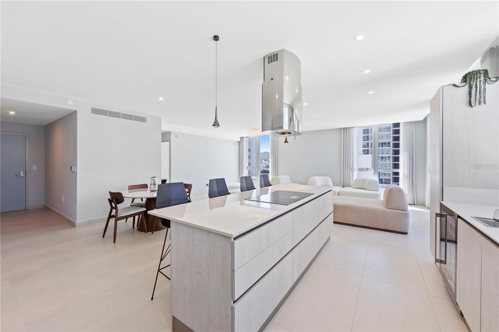 A modern open-concept kitchen and living area featuring a central island with a stainless hood — 14 CALLE DELCASSE UNIT 703, SAN JUAN, PR