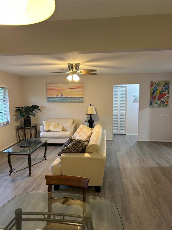 A living room features light wood-look flooring, a white sofa, and a glass coffee table — 209 MATISSE CIRCLE, NOKOMIS, FL