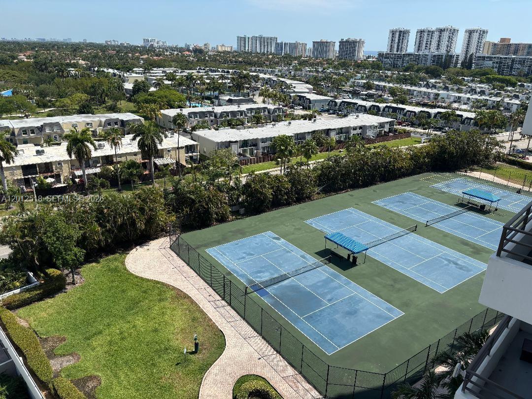 An elevated view shows two tennis courts next to a lawn and residential buildings — 600 Three Islands Blvd # 1003, Hallandale Beach FL 33009, HALLANDALE BEACH, FL