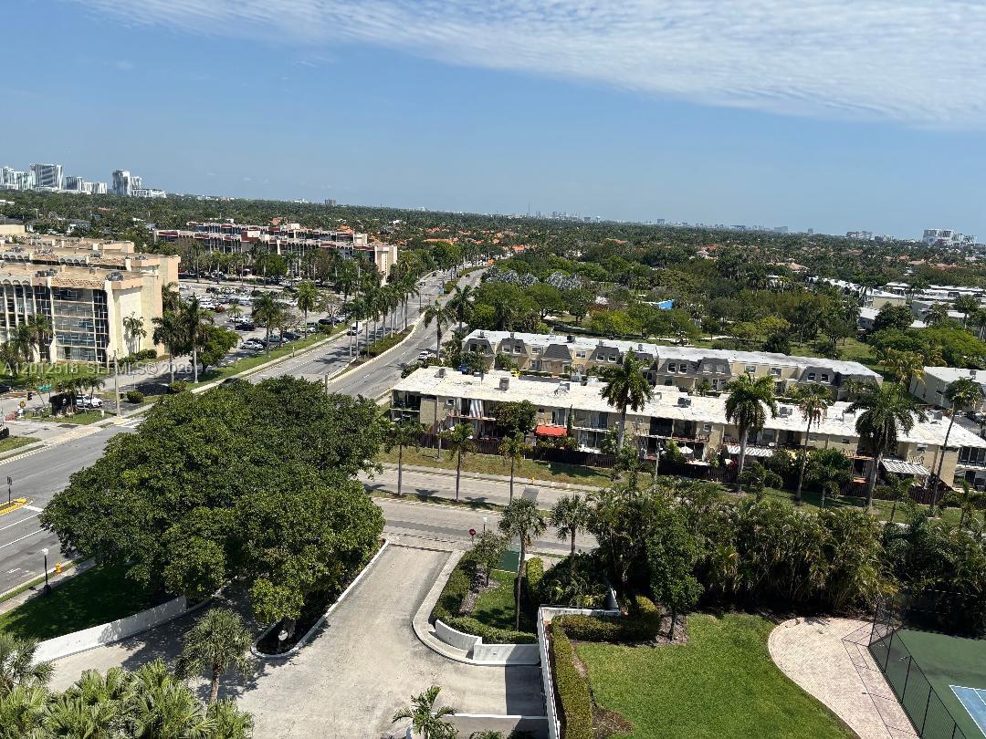 An elevated view shows a residential area with apartment buildings, palm trees, and a road — 600 Three Islands Blvd # 1003, Hallandale Beach FL 33009, HALLANDALE BEACH, FL