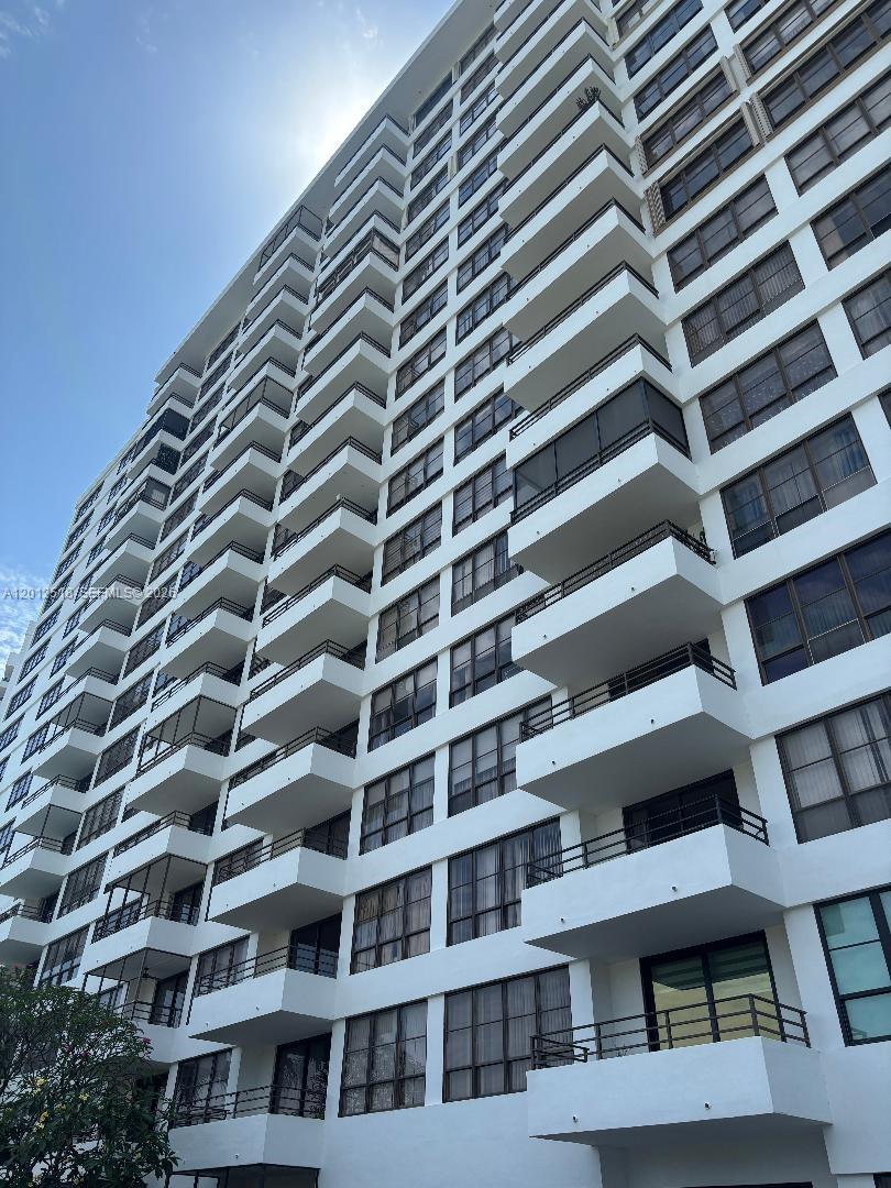A low-angle view of a white high-rise residential building with multiple stacked balconies — 600 Three Islands Blvd # 1003, Hallandale Beach FL 33009, HALLANDALE BEACH, FL