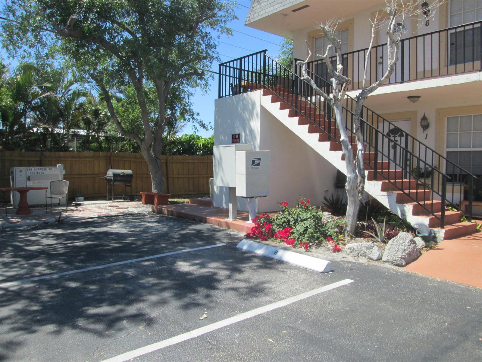 An exterior view of an apartment building with a staircase, mailbox station, and parking area — 405 N Cypress Drive # 8, Jupiter FL 33469, JUPITER, FL