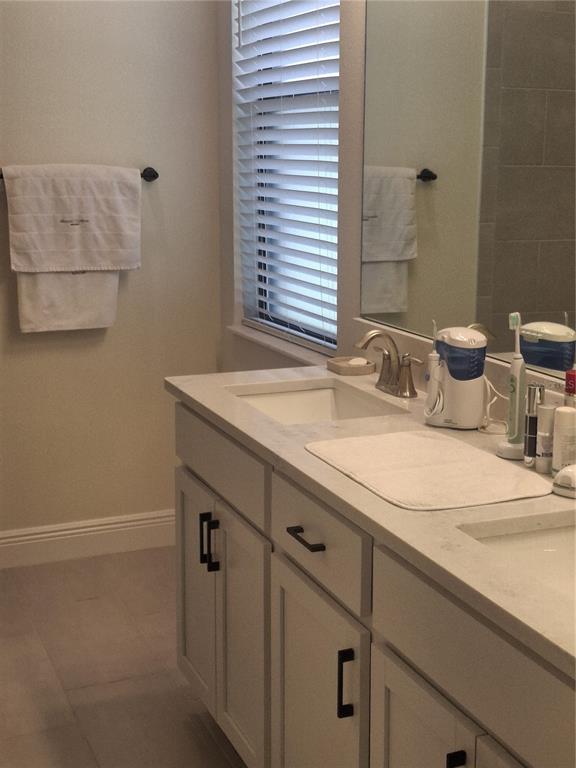 A bathroom features a double vanity with white cabinets, black hardware, and a light countertop — 12618 VANDER WAY, NEW PORT RICHEY, FL