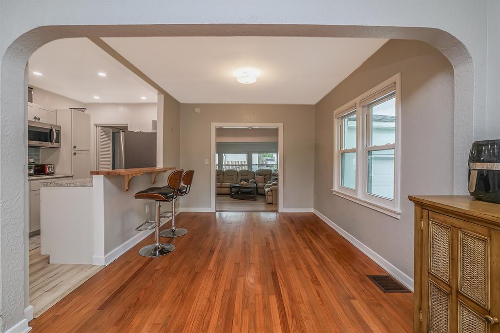 A dining area with hardwood floors leads to a kitchen with a breakfast bar — 532 HILLSIDE AVENUE, DAYTONA BEACH, FL