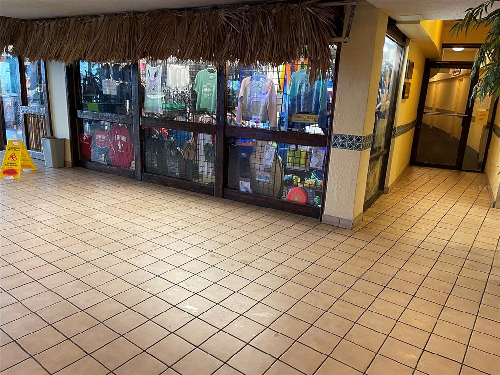 A retail storefront with a thatched roof awning and tiled flooring in a hallway — 2301 S ATLANTIC AVENUE UNIT 328, DAYTONA BEACH SHORES, FL