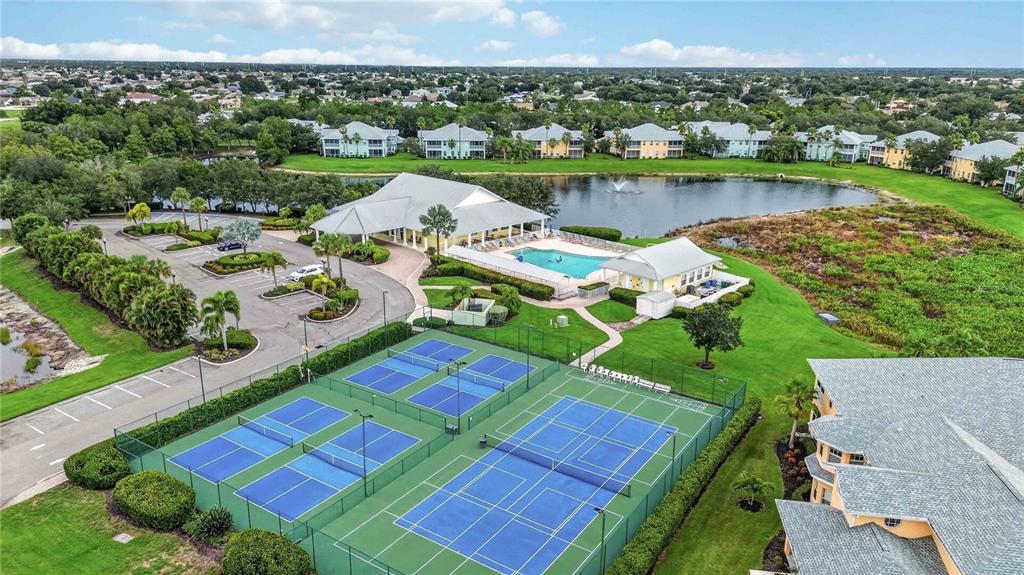 An aerial view shows a community clubhouse with a swimming pool and tennis courts — 2160 HERON LAKE DRIVE UNIT 108, PUNTA GORDA, FL