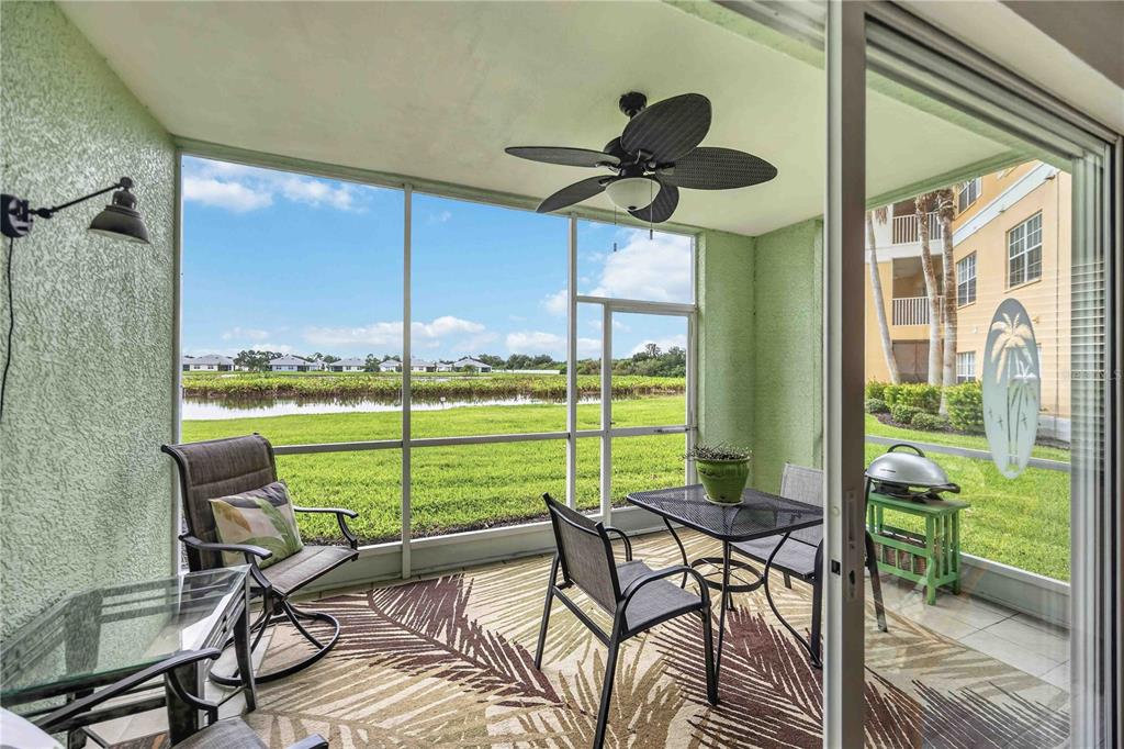 A screened-in porch with patio furniture, a ceiling fan, and a view of a pond — 2160 HERON LAKE DRIVE UNIT 108, PUNTA GORDA, FL