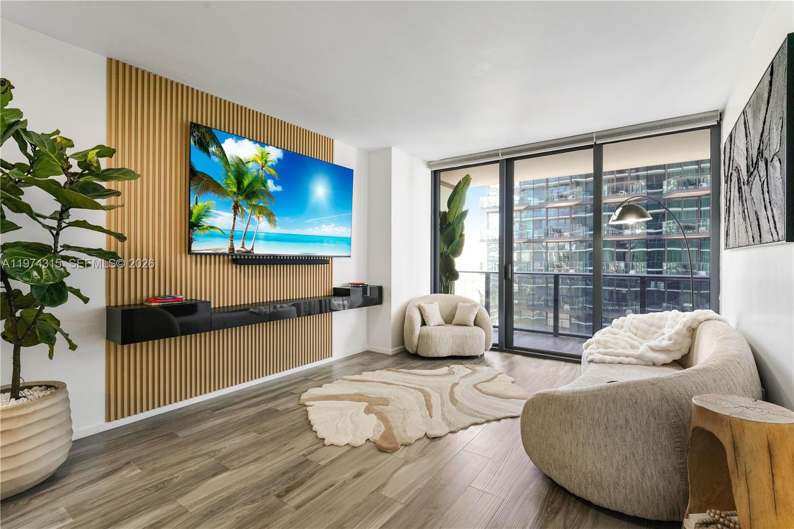 A modern living room features a slatted wood accent wall, floating black shelf, and balcony — 801 S Miami Ave # 3107, Miami FL 33130, MIAMI, FL