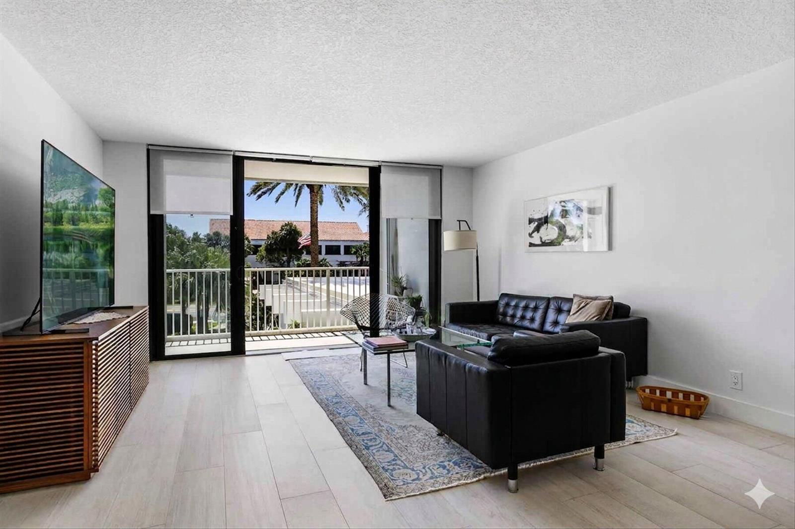 A living room features light wood floors, black leather furniture, and a balcony with palm trees — 2860 S Ocean Boulevard # 216, Palm Beach FL 33480, PALM BEACH, FL
