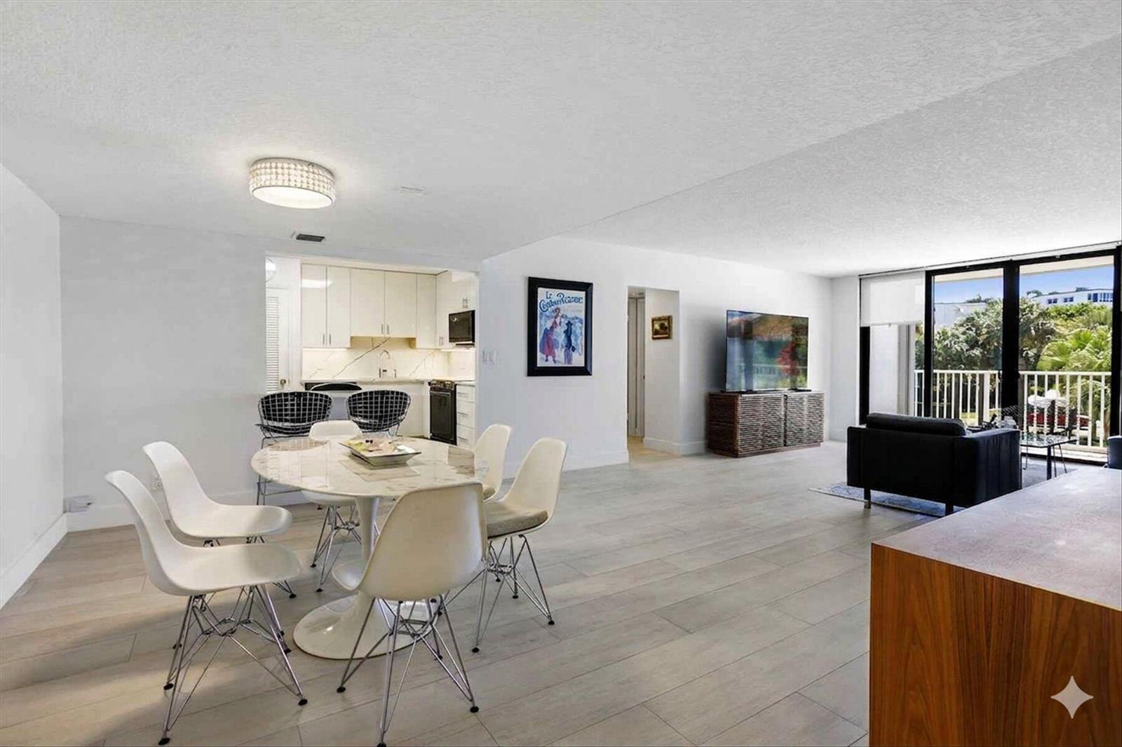 An open-concept living and dining area features white walls, light wood-look flooring, and a balcony — 2860 S Ocean Boulevard # 216, Palm Beach FL 33480, PALM BEACH, FL