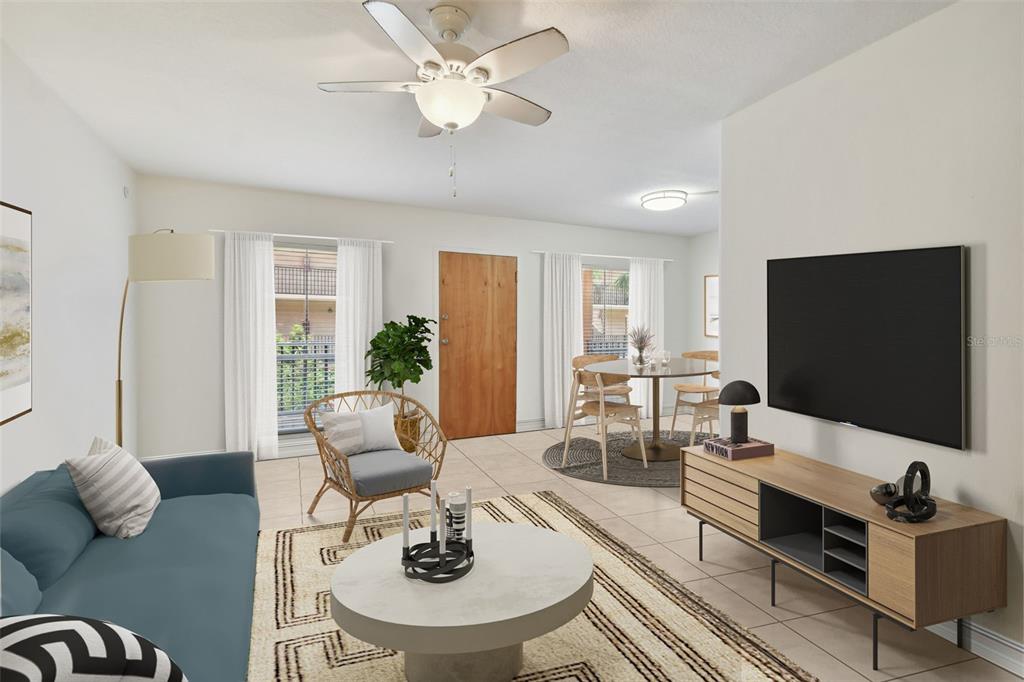 A living room with a blue sofa, a round coffee table, and a dining area — 8931 BLIND PASS ROAD UNIT 257, ST PETE BEACH, FL