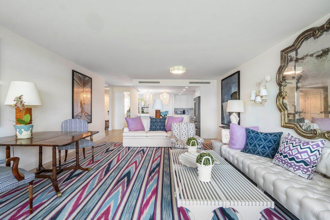 A living room with a striped rug, white tufted sofa, and a large ornate mirror — 2170 Ibis Isle Road # 3, Palm Beach FL 33480, PALM BEACH, FL