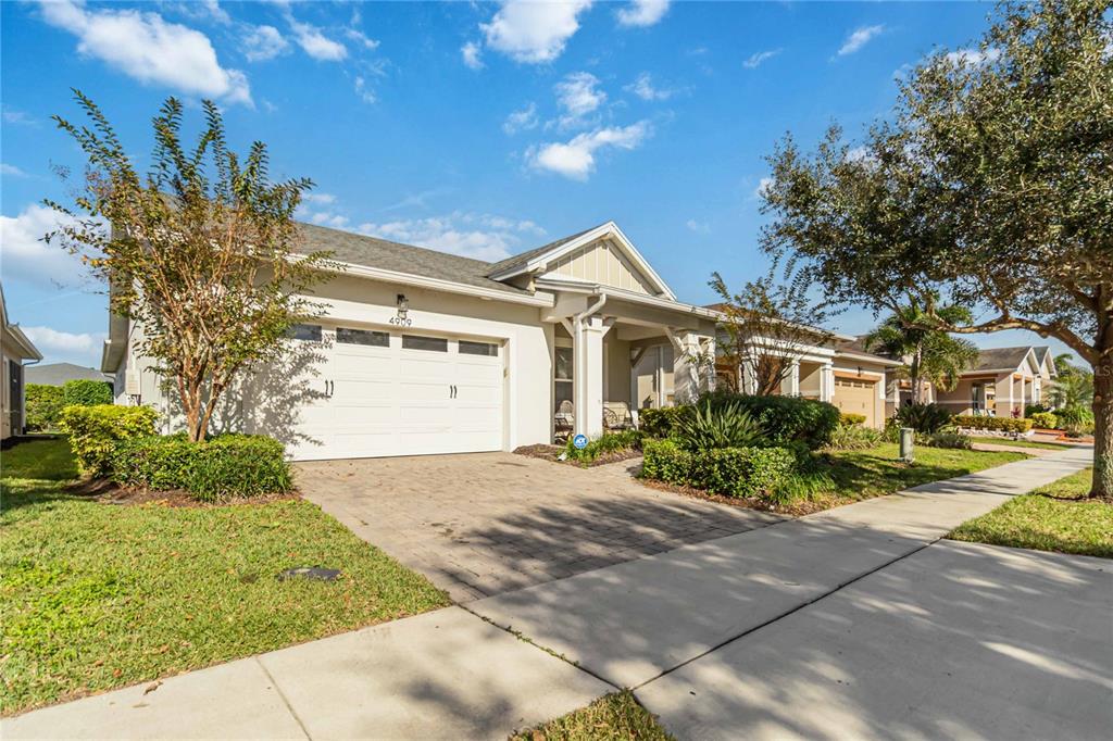 A single-story house with a white garage, paved driveway, and landscaped front yard — 4909 W FOUNTAINWOOD DRIVE, ST CLOUD, FL