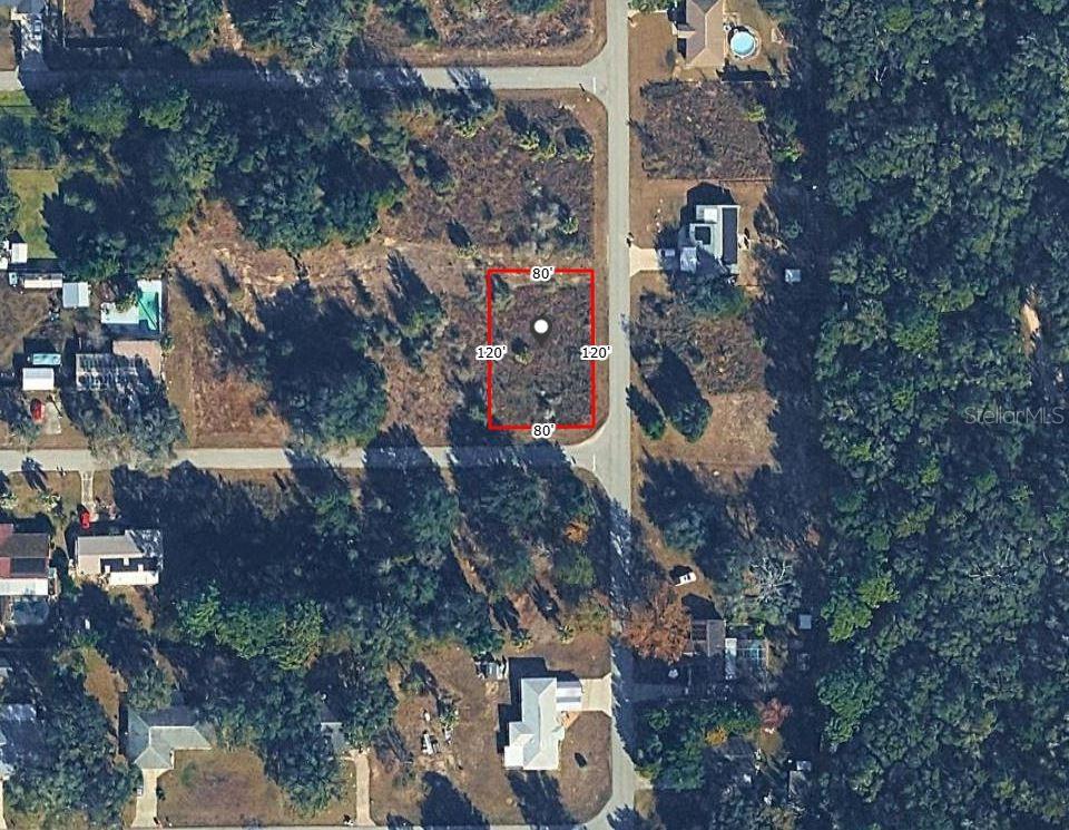 An aerial view shows a rectangular vacant lot marked with red boundary lines — SW 82ND PL, DUNNELLON, FL