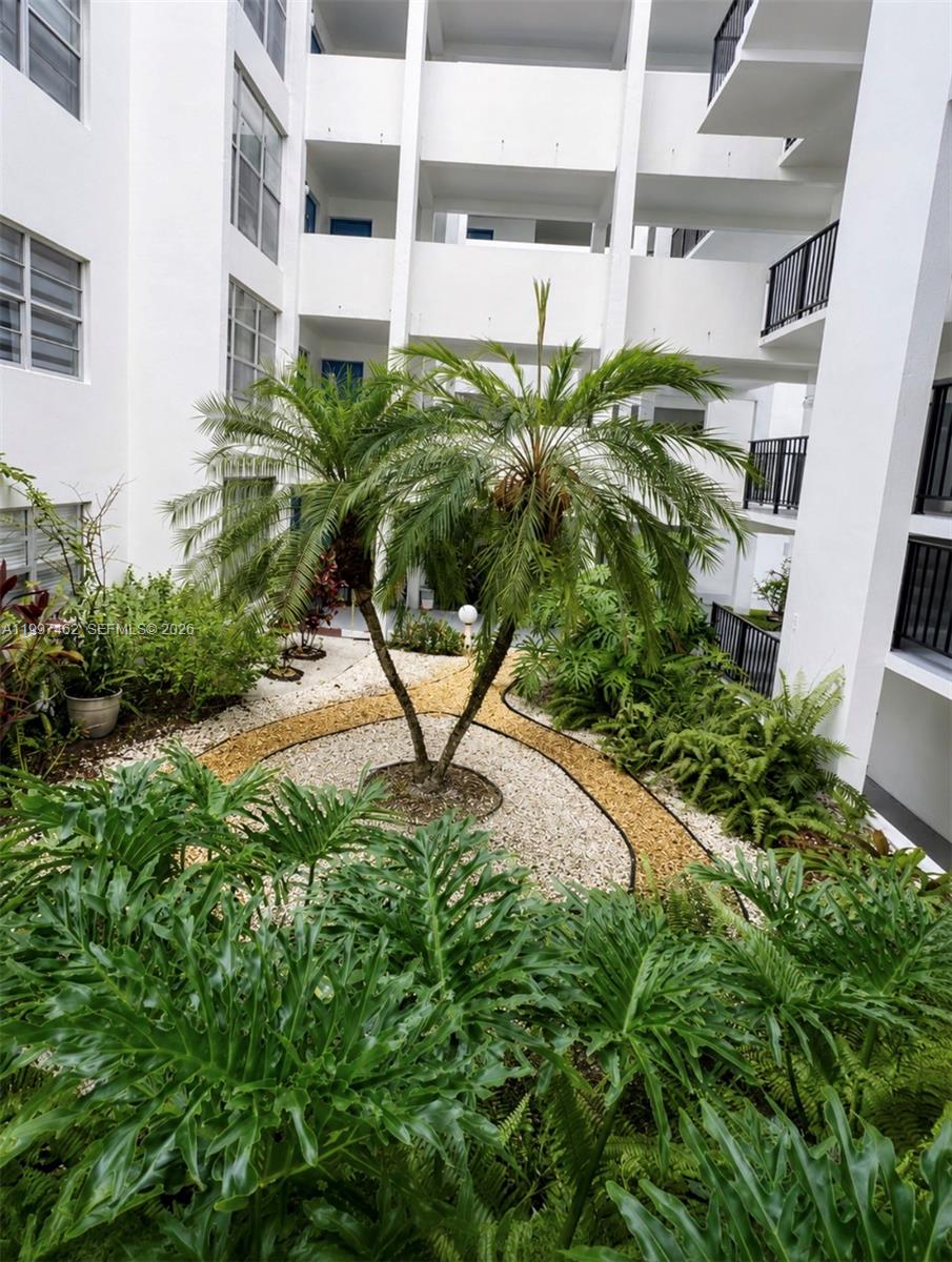 A courtyard with a central palm tree surrounded by gravel paths and lush green plants — 6901 Cypress Rd # B17, Plantation FL 33317, PLANTATION, FL