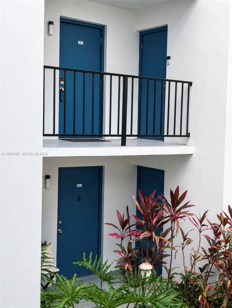 This exterior view shows two levels of apartment entry doors with blue paint and a balcony — 6901 Cypress Rd # B17, Plantation FL 33317, PLANTATION, FL