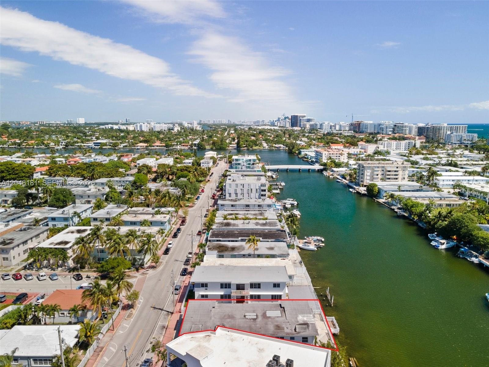 An aerial view shows a multi-story building with a flat roof bordering a canal — 8135 Crespi Blvd # 4, Miami Beach FL 33141, MIAMI BEACH, FL