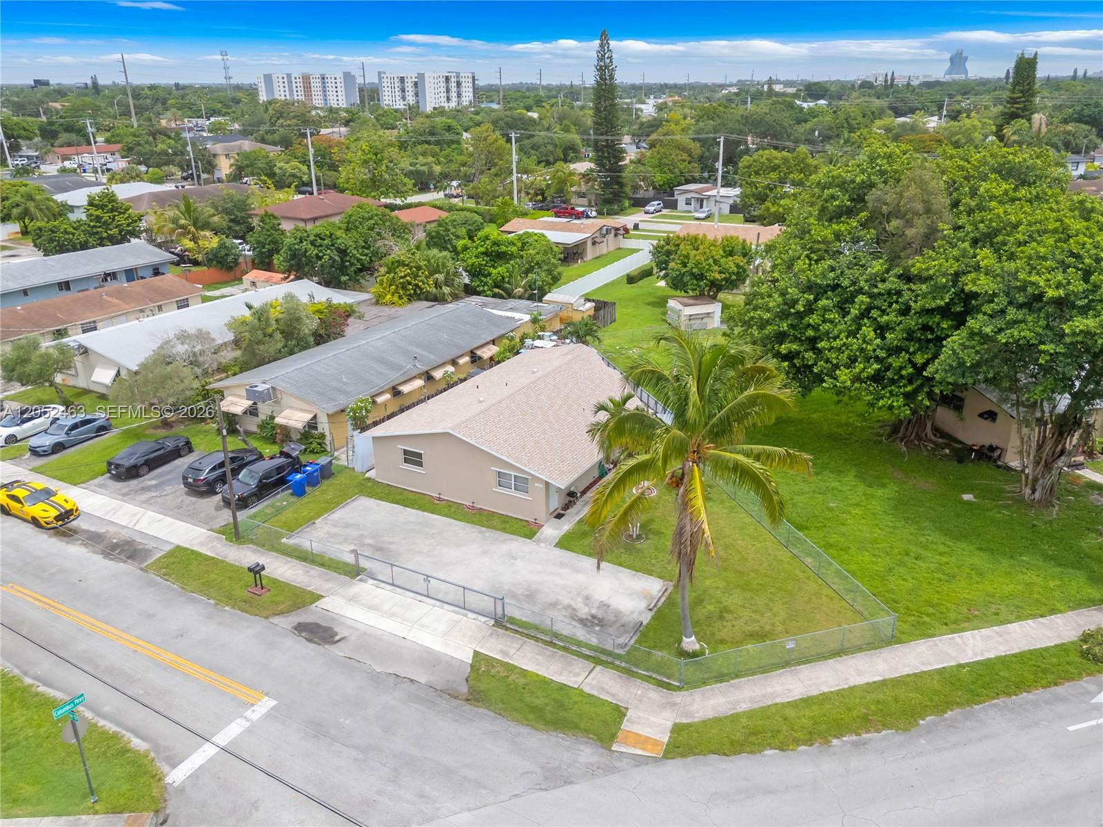 An aerial view shows a tan house with a palm tree and a fenced yard — 5829 Taylor St, Hollywood FL 33021, HOLLYWOOD, FL