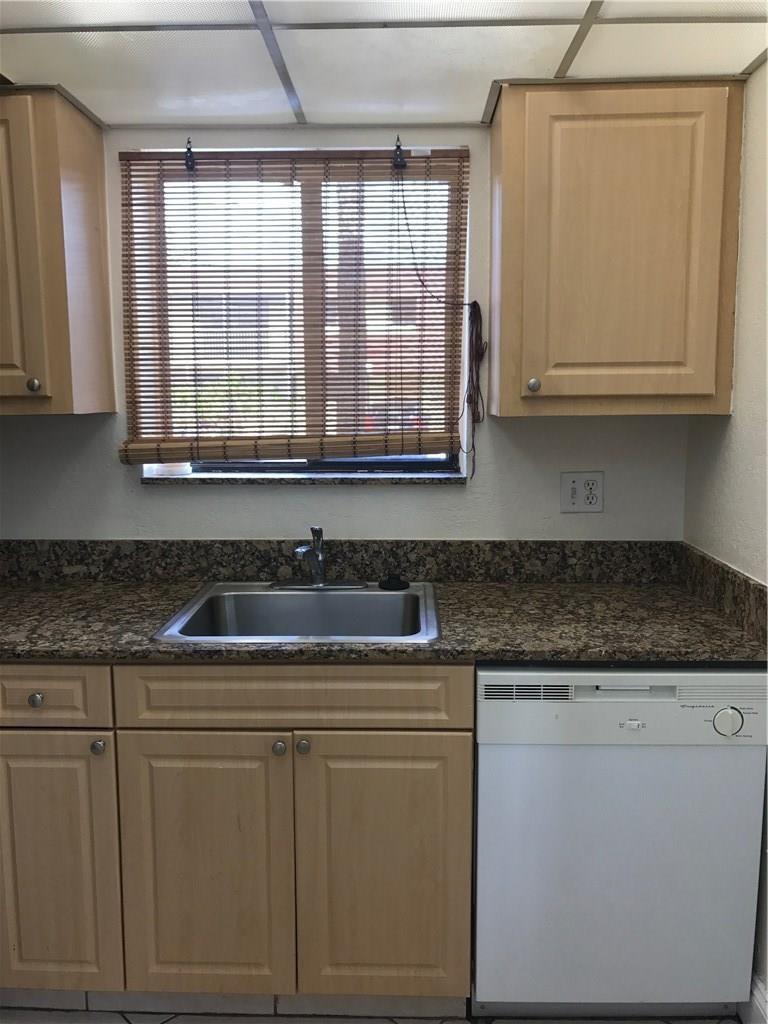 A kitchen features light wood cabinets, granite countertops, a stainless steel sink, and a dishwasher — 1105 S Flagler Avenue # 601, Pompano Beach FL 33060, POMPANO BEACH, FL