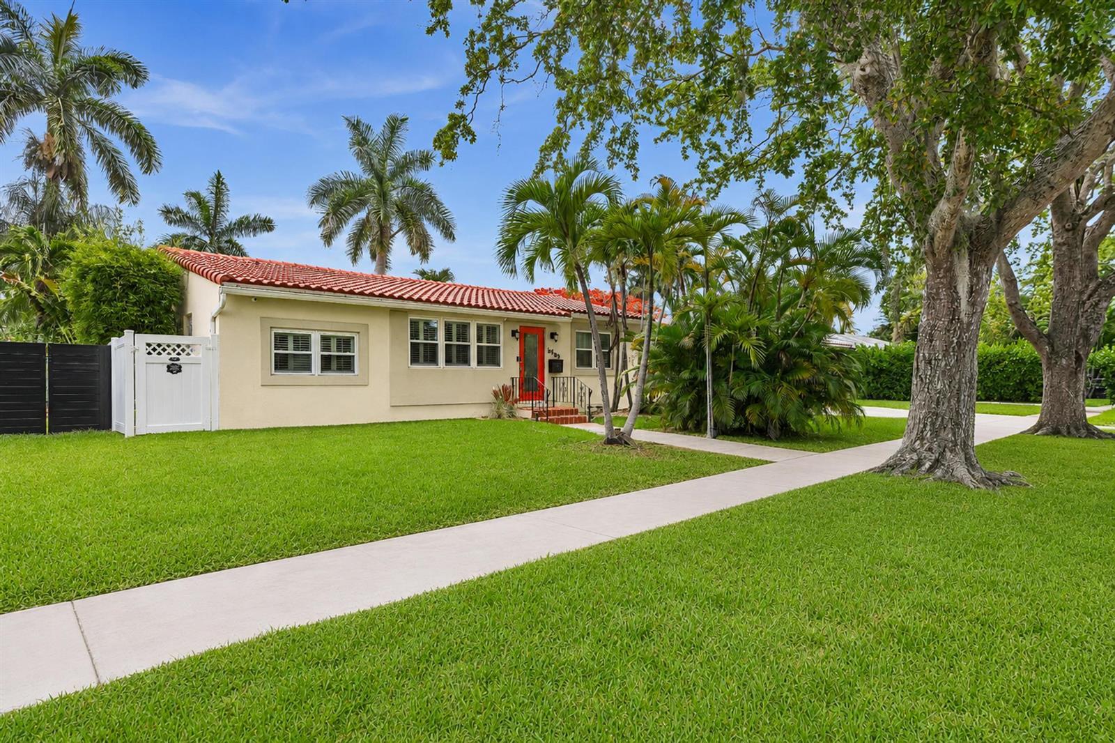 A single-story house with a red tile roof, beige exterior, and a bright red door — 1527 Mayo Street, Hollywood FL 33020, HOLLYWOOD, FL