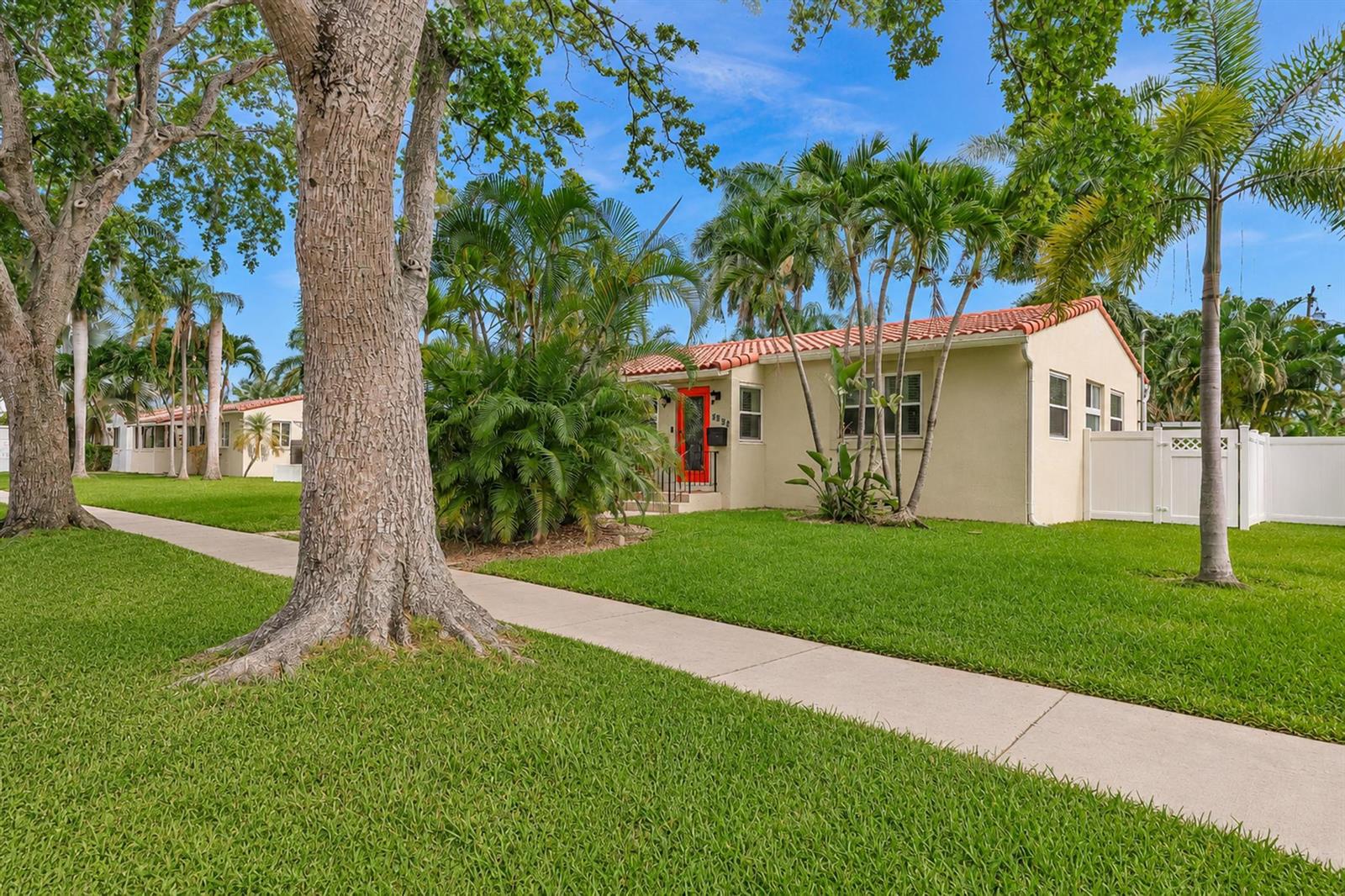 A single-story house with a red door and tile roof sits on a grassy lawn — 1527 Mayo Street, Hollywood FL 33020, HOLLYWOOD, FL