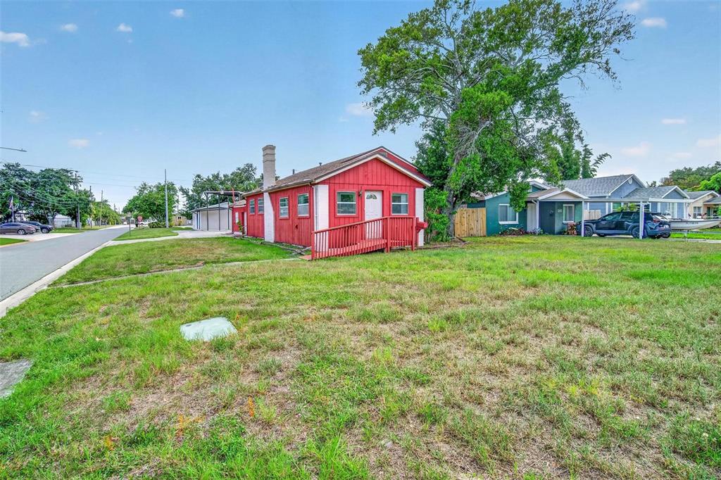 A small red house with a wheelchair ramp sits on a grassy lot — 2600 25TH AVENUE N, ST PETERSBURG, FL