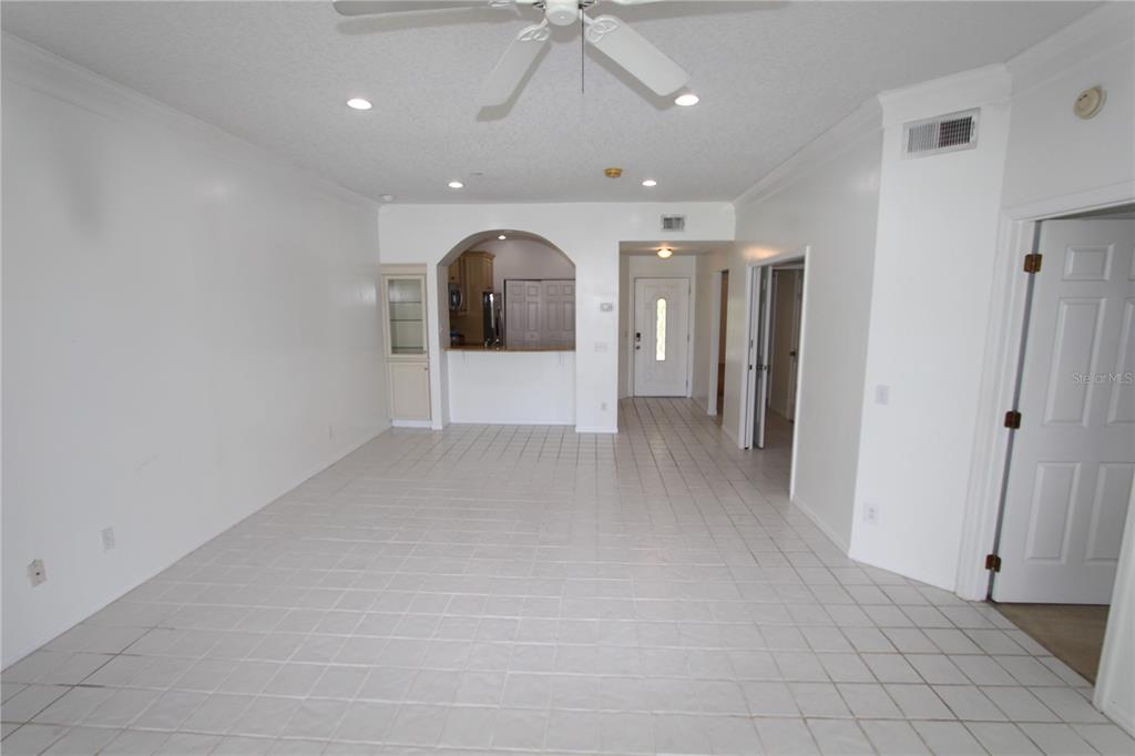 An open-concept living area features white tile flooring, a ceiling fan, and a kitchen pass-through — 451 HAMPTONCREST CIRCLE UNIT 307, LAKE MARY, FL