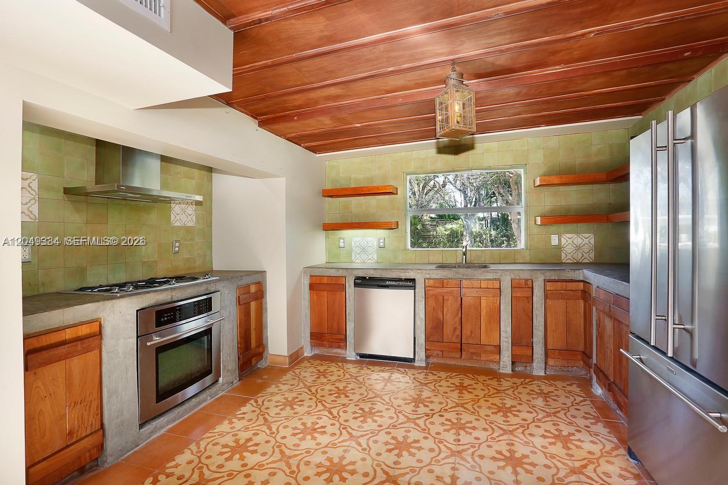 A kitchen features concrete countertops, wood cabinetry, patterned tile flooring, and a wood-paneled ceiling — 6116 SW 46th Ter, Miami FL 33155, MIAMI, FL