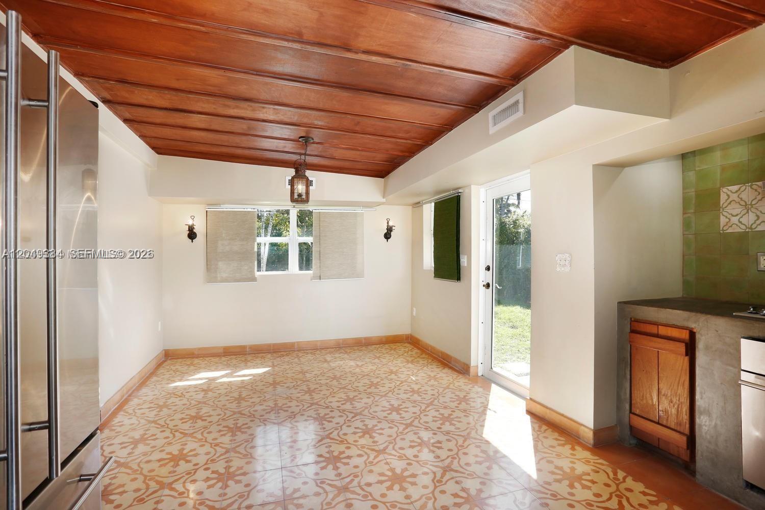 A kitchen with patterned tile floors, a wood-paneled ceiling, and a concrete countertop — 6116 SW 46th Ter, Miami FL 33155, MIAMI, FL
