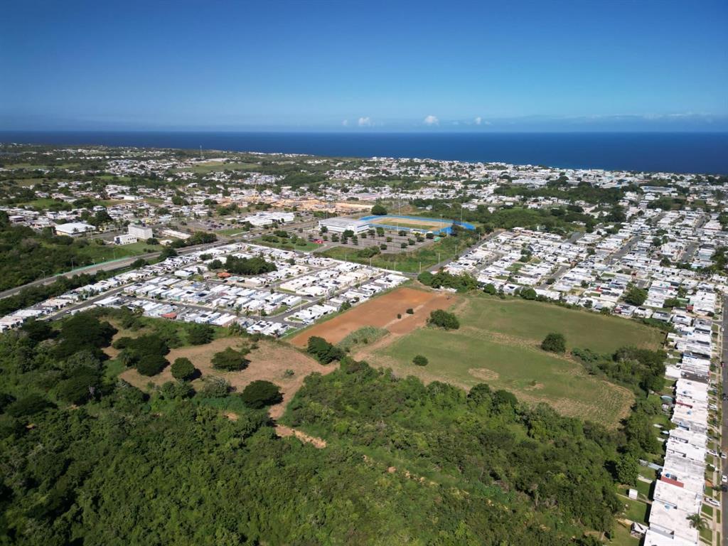 Aerial view of a residential neighborhood with a sports field and surrounding green space — MASIONES DEL ATLANTICO, ISABELA, PR