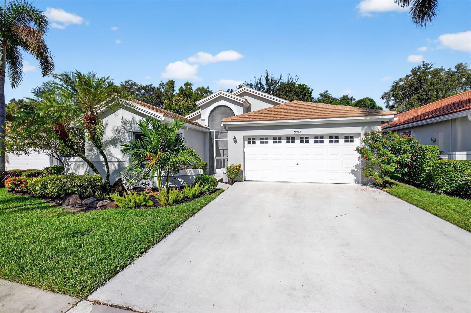 A single-story house with a white garage, a tiled roof, and landscaped front yard — 9914 Harbour Lake Circle, Boynton Beach FL 33437, BOYNTON BEACH, FL