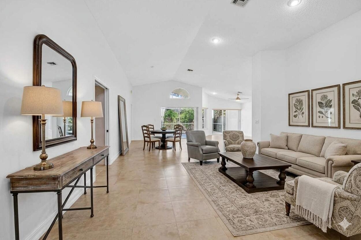 A living and dining area with tile floors, vaulted ceilings, and neutral furniture — 9914 Harbour Lake Circle, Boynton Beach FL 33437, BOYNTON BEACH, FL