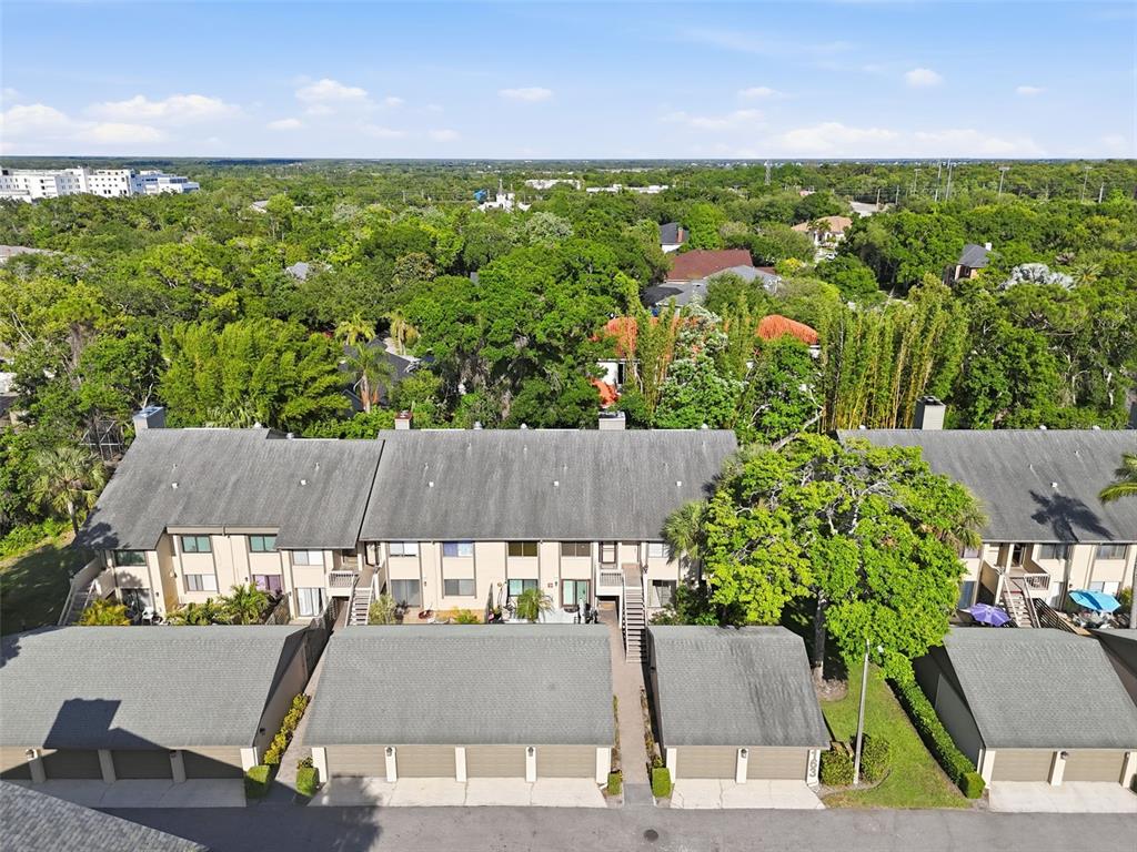 An aerial view shows a row of townhouses with attached garages and surrounding trees — 3163 LANDMARK DRIVE UNIT 615, CLEARWATER, FL