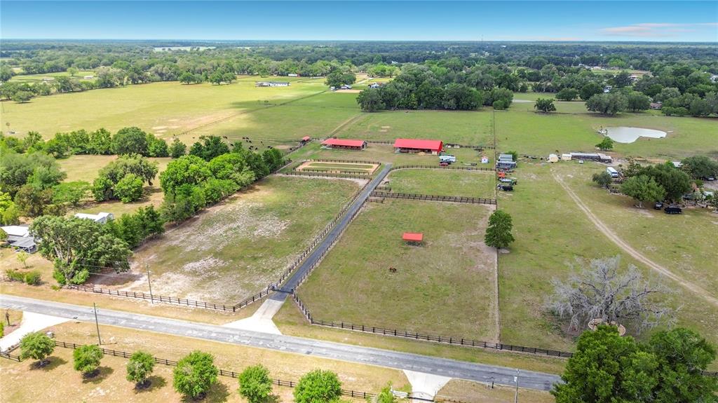 An aerial view shows a large rural property with fenced pastures, barns, and trees — 16750 SE 19TH COURT, SUMMERFIELD, FL