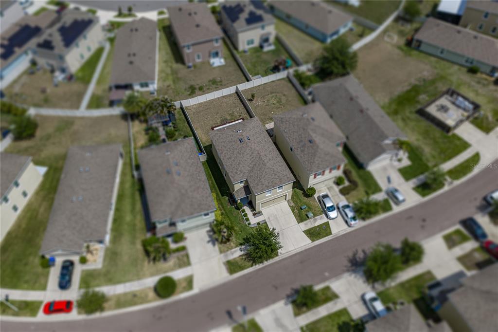 An aerial view shows a suburban neighborhood with several detached houses and their surrounding yards — 16833 TRITE BEND STREET, WIMAUMA, FL