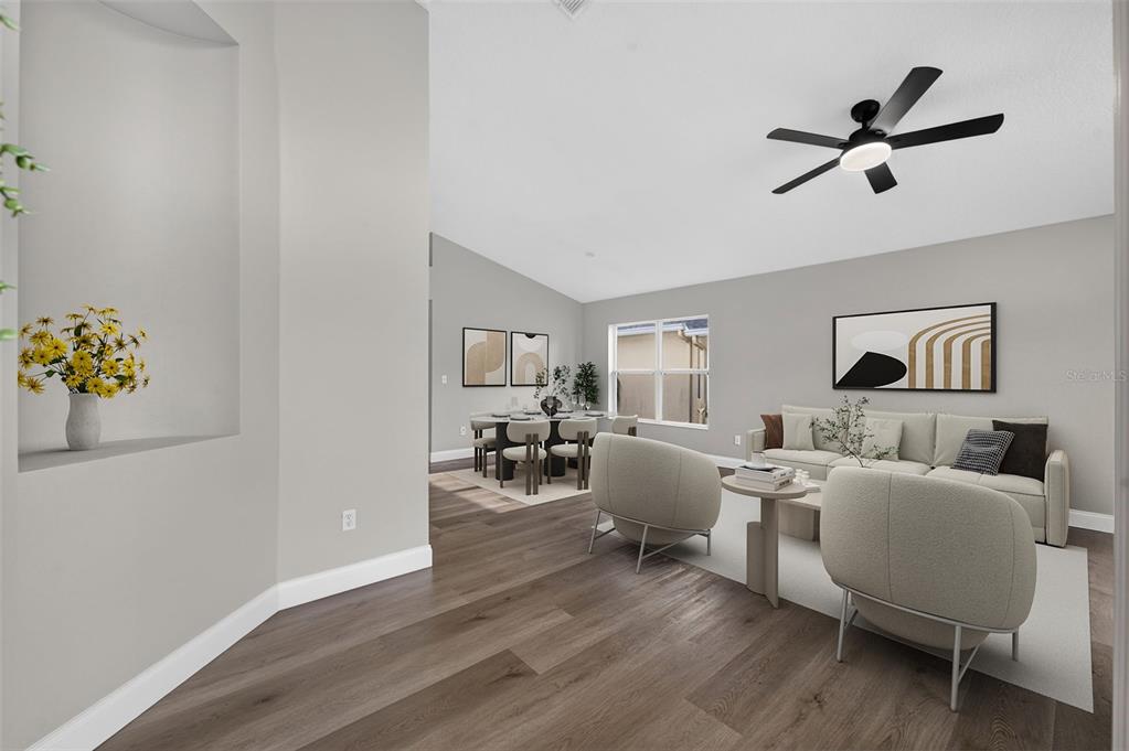 This virtually staged living and dining area features light gray walls and wood-look flooring — 14229 SAPPHIRE BAY CIRCLE, ORLANDO, FL