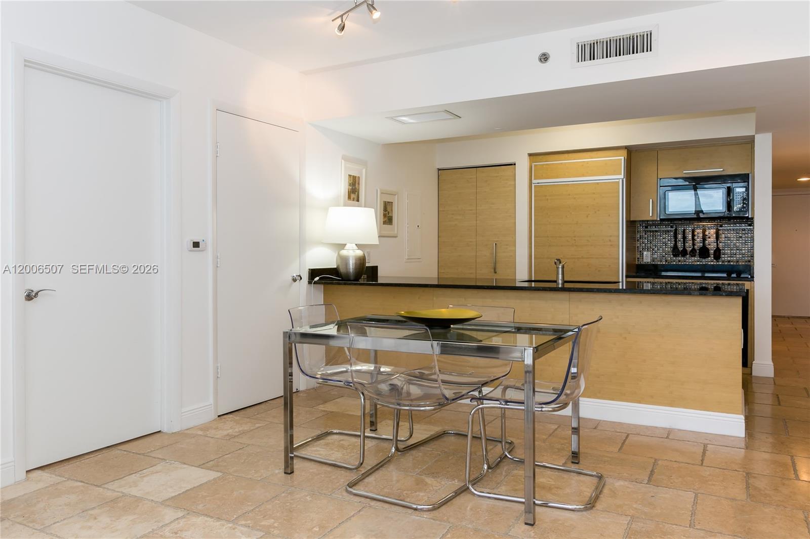 A dining area with a glass table and clear chairs sits before a kitchen counter — 1830 S OCEAN DR # 4010, Hallandale Beach FL 33009, HALLANDALE BEACH, FL