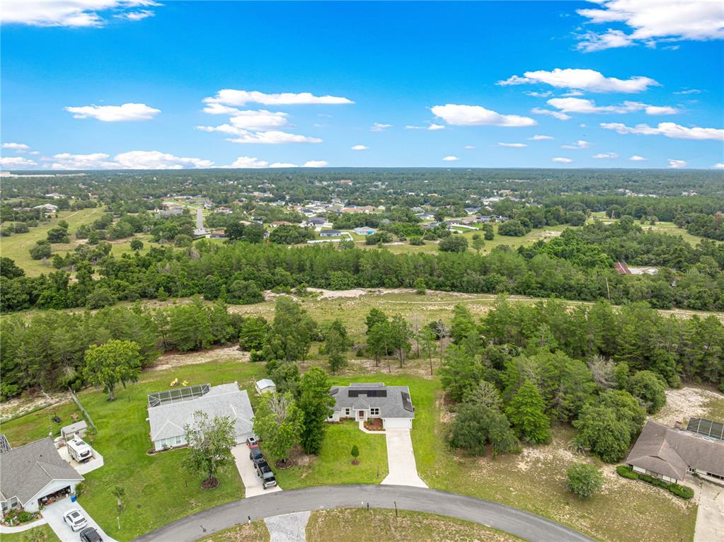 An aerial view shows a single-story house with a screened-in porch and solar panels — 16614 SW 45TH CIRCLE, OCALA, FL