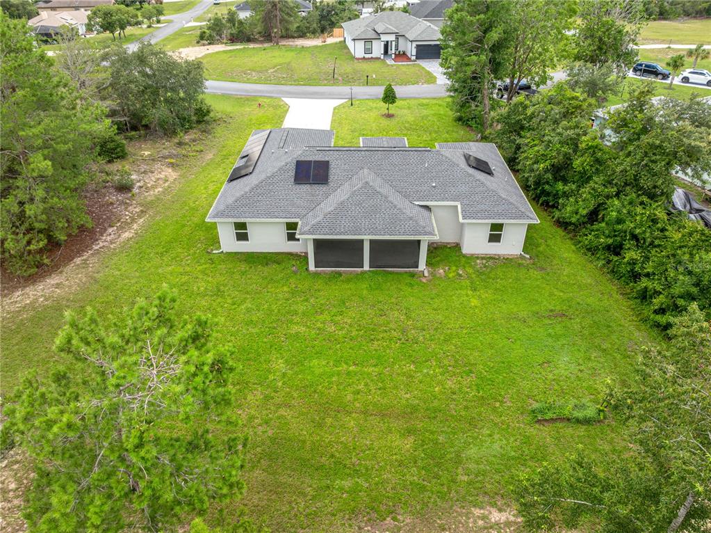 An aerial view shows a single-story house with a large backyard and surrounding trees — 16614 SW 45TH CIRCLE, OCALA, FL