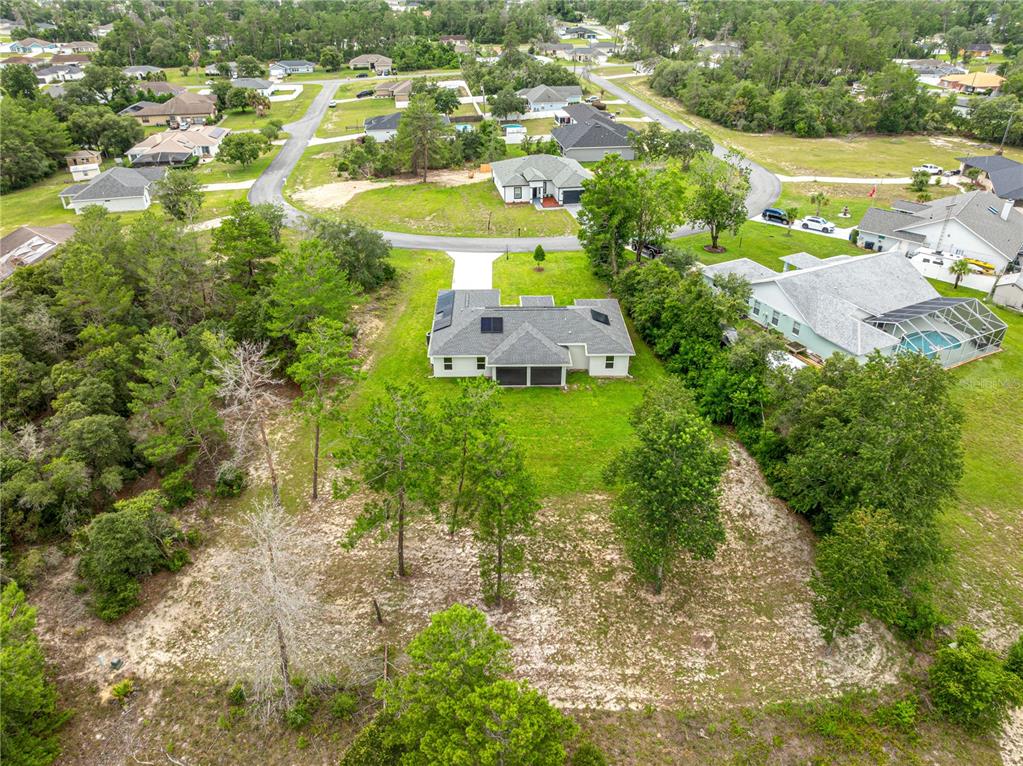 An aerial view shows a single-story house with solar panels on the roof — 16614 SW 45TH CIRCLE, OCALA, FL
